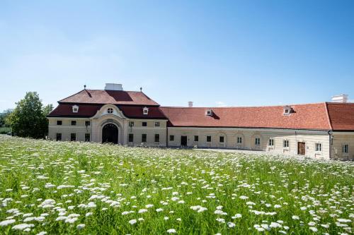 a building with a field of flowers in front of it at Gästehaus Benediktinerstift Göttweig - Bed & Breakfast Monastery in Furth