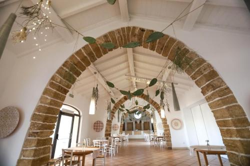 an archway in a room with tables and chairs at Tenuta Moreno in Mesagne