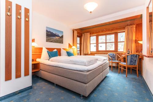 Habitación de hotel con cama, mesa y sillas en Landgasthof Neuwirt, en Lofer