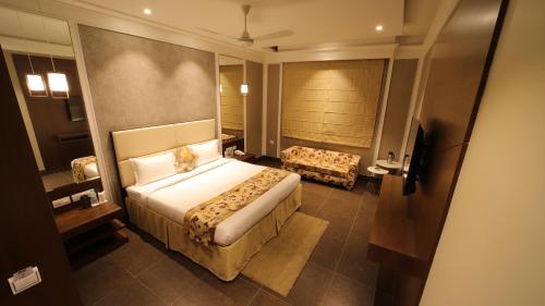 a hotel room with a large bed and a couch at THE GRAND VILLAGE in Morādābād