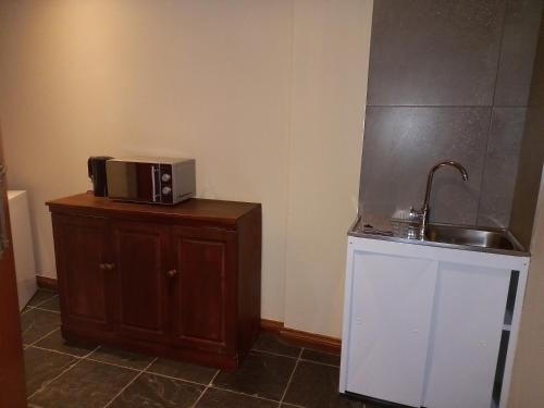 a kitchen with a sink and a microwave on a cabinet at Troas Boutique hotel in Vanderbijlpark