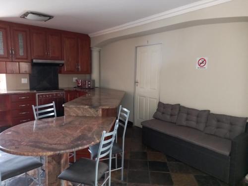a kitchen and living room with a table and a couch at Troas Boutique hotel in Vanderbijlpark
