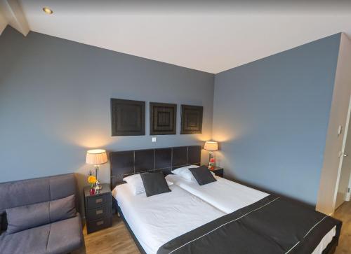 a bedroom with a large bed and a couch at Boutique Hotel Chariot - Amsterdam Schiphol Airport in Aalsmeer
