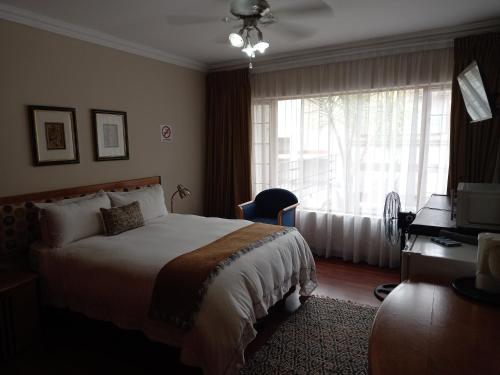 a hotel room with a bed and a window at Troas Boutique hotel in Vanderbijlpark