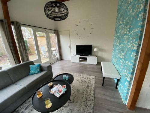 a living room with a couch and a table at Rekerlanden 119 de Amandelbloesem in Schoorldam