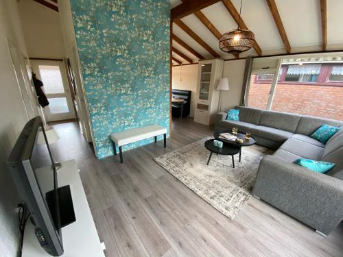 a living room with a couch and a table at Rekerlanden 119 de Amandelbloesem in Schoorldam