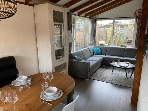 a living room with a couch and a table at Rekerlanden 119 de Amandelbloesem in Schoorldam