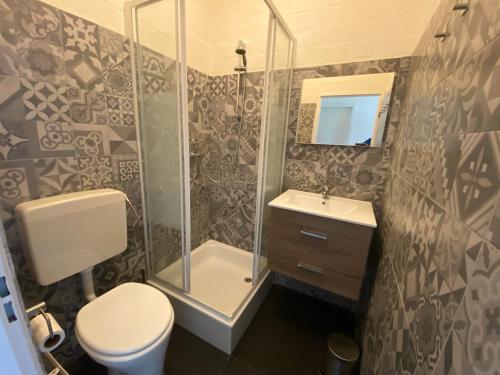 a bathroom with a shower and a toilet and a sink at Rekerlanden 119 de Amandelbloesem in Schoorldam