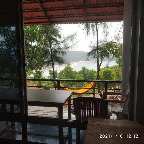 a view from the balcony of a house with a table and chairs at Niramaya beach view stay in Gokarna