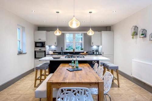 a kitchen with a wooden table and chairs at North Lodge in Lancaster