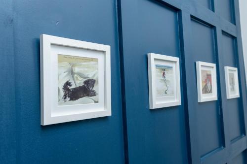 three framed pictures of a dog on a blue wall at North Lodge in Lancaster