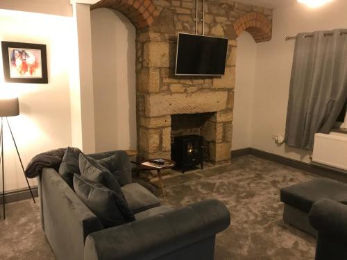 a living room with a couch and a fireplace at North Lodge in Lancaster