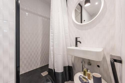 a white bathroom with a sink and a mirror at Apartamento Tirso en Madrid in Madrid
