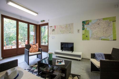 Il comprend un salon doté de meubles et d'une télévision. dans l'établissement Camping de Bourges, à Bourges