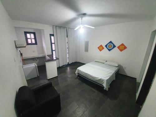 a room with a bed and a chair in it at Santorini Flats in Arraial do Cabo