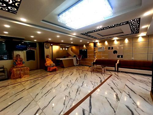 a lobby with a large marble floor and a skylight at Hotel Om International in Bodh Gaya