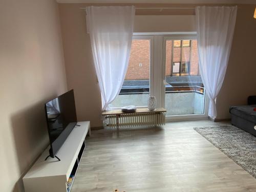 sala de estar con TV y ventana grande en Apartment im Herzen von Bad Salzuflen am Kurpark, en Bad Salzuflen