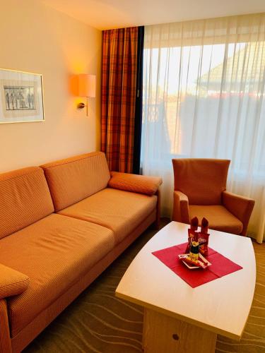 a living room with a couch and a table at Aparthotel Kleine Perle in Cuxhaven