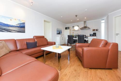 a living room with a couch and a table at Ferienwohnungen MARENOR in Bensersiel