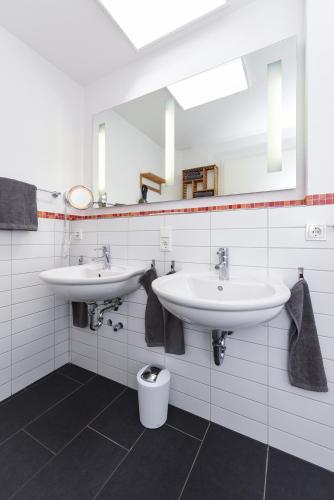 a bathroom with two sinks and a toilet at Ferienwohnungen MARENOR in Bensersiel