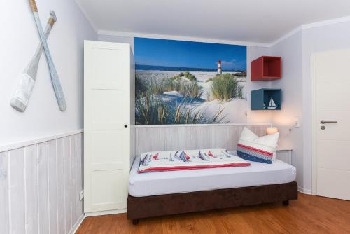 a bedroom with a bed with a painting on the wall at Ferienwohnungen MARENOR in Bensersiel
