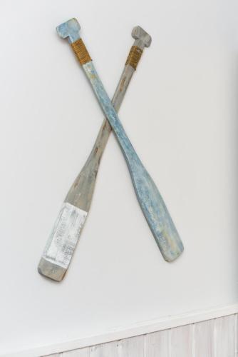 two old axes hanging on a white wall at Ferienwohnungen MARENOR in Bensersiel