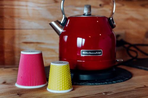 a red blender sitting on a table with two cups at Les Mazots du Clos in Villars-sur-Ollon