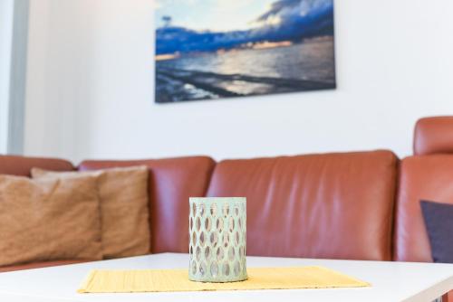 a vase sitting on a table in front of a couch at Ferienwohnungen MARENOR in Bensersiel