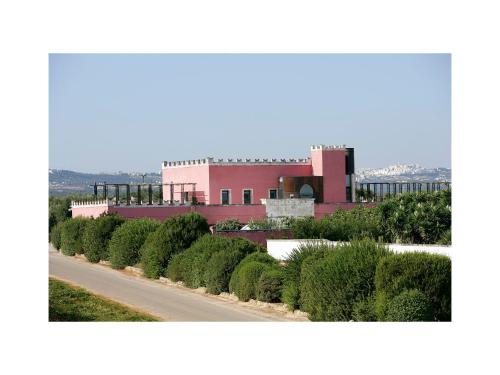 a road in front of a pink building at Grand Hotel Masseria Santa Lucia in Ostuni