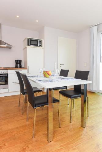 a dining room with a table and chairs at Ferienwohnungen MARENOR in Bensersiel