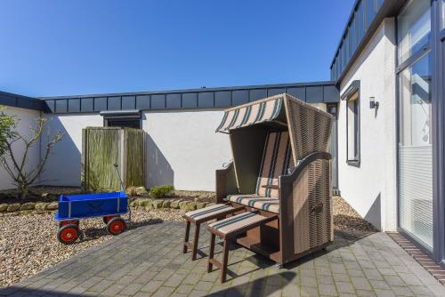 a group of chairs on a patio next to a building at Ferienwohnungen MARENOR in Bensersiel