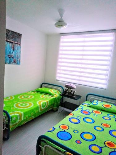 a bedroom with two beds and a window at PeñalisaKapoSalSar in Girardot