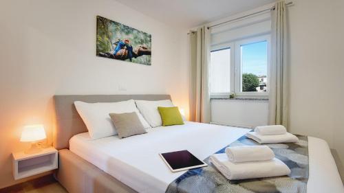 um quarto com uma grande cama branca e uma janela em Exclusive Pula City Apartments em Pula