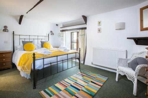 una camera con un letto, una sedia e un tappeto di Jasmine Cottage a Bude