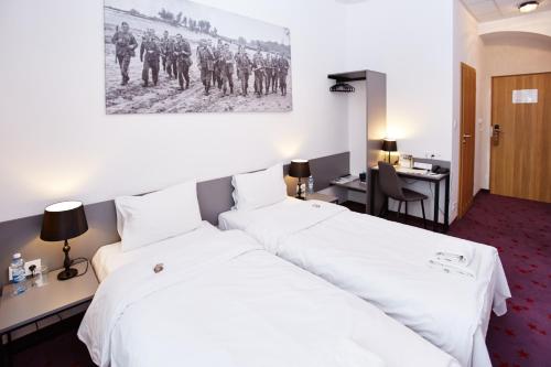 a hotel room with two beds and a desk at Koszary Arche Hotel in Góra Kalwaria