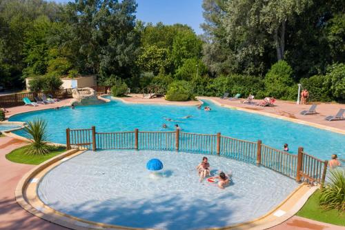 un grupo de personas jugando en una piscina en Camping du Pont d'Avignon, en Aviñón
