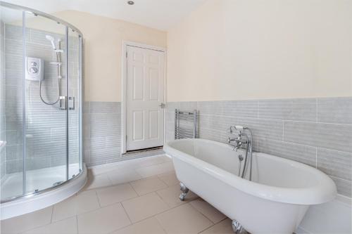 a white bathroom with a tub and a shower at Guest Homes - Southfield Dwelling in Worcester