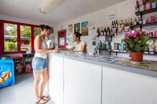 モンルイ・シュル・ロワールにあるCamping de Montlouis-sur-Loireの二人の女がバーのカウンターに立っている