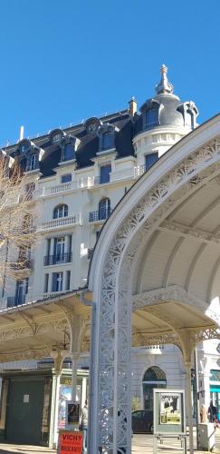 a large white building with an arch in front of it at Demeures & Châteaux Le Pavillon d'Enghien, Vichy Centre in Vichy