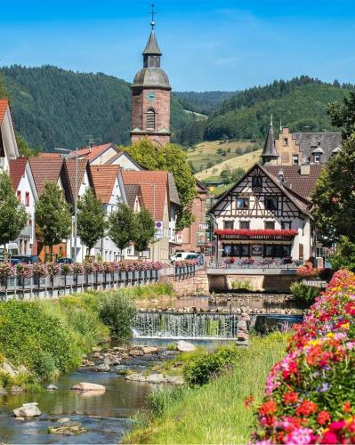 a small town with a river and a church at Hotel Restaurant Rebstock in Oppenau