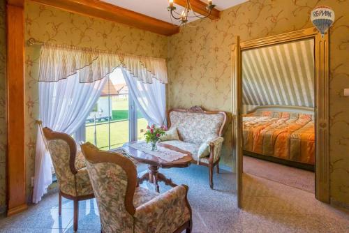 a bedroom with a bed and a table and chairs at Ranczo Kalinka in Wiżajny