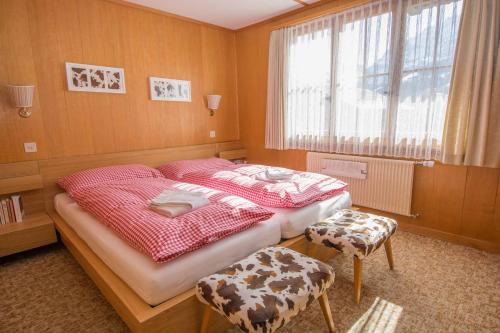 a bedroom with two beds and a window at Chalet Happy in Adelboden