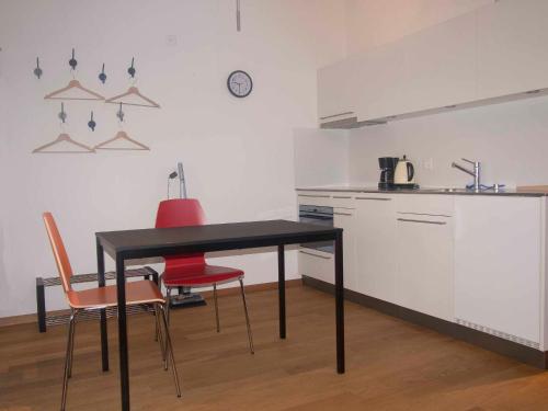 een keuken met een zwarte tafel en 2 stoelen bij Studio Zentrum OG in Adelboden