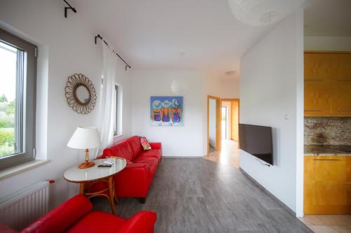 a living room with a red couch and a table at Villa Medusa in Portorož