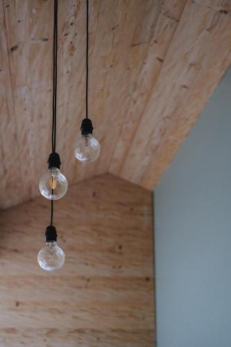 a group of lights hanging from a wooden ceiling at Les Mazots du Clos in Villars-sur-Ollon