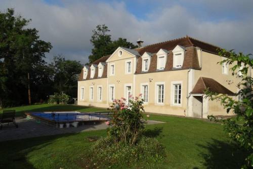 une grande maison avec une piscine en face de celle-ci dans l'établissement Gîte Château de Montboulon 4* Spa+piscine 14pers., à Saint-Georges-sur-Baulche