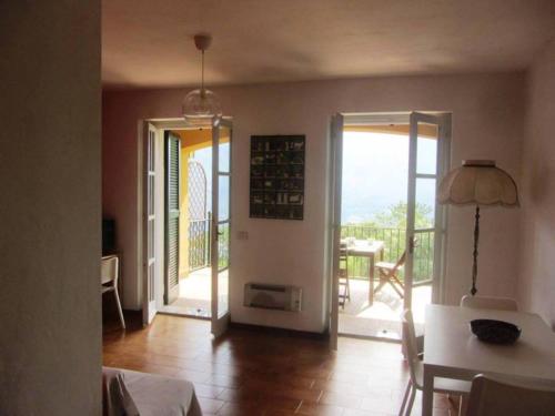 ein Wohnzimmer mit einer Tür, die auf einen Balkon führt in der Unterkunft IL BALCONE SUL LAGO in Magreglio