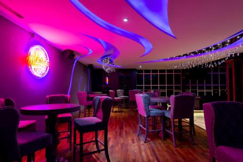 a restaurant with purple lighting and tables and chairs at HOTEL & SPA MANSION SOLIS by HOTSSON in Morelia