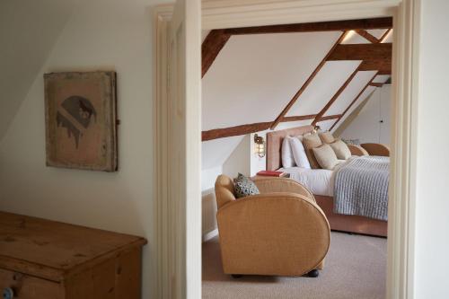 a bedroom with a bed and a chair in a room at The Tower Rooms in Fakenham