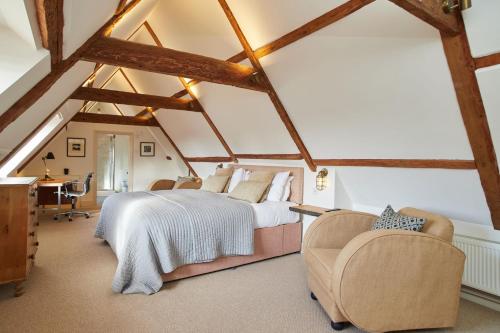 a bedroom with a bed and chairs in a attic at The Tower Rooms in Fakenham